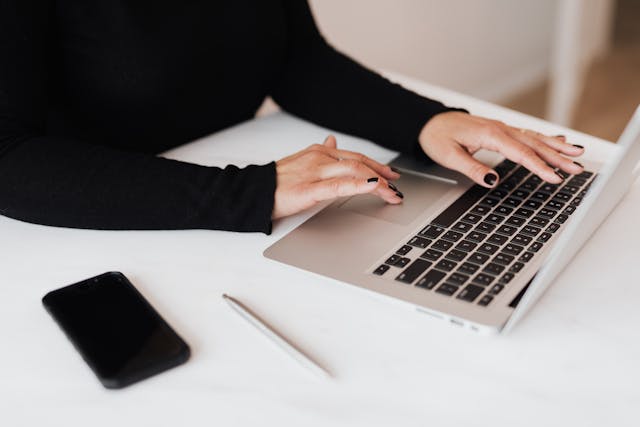 A crop faceless woman working on netbook in the office